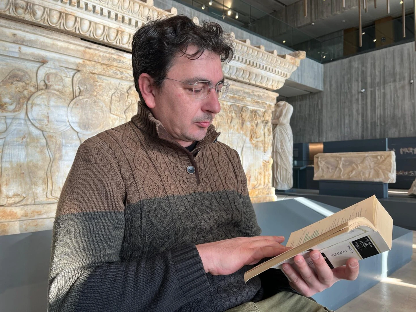 A participant reading Homer's Iliad in front of the Polyxena Sarcophagus.