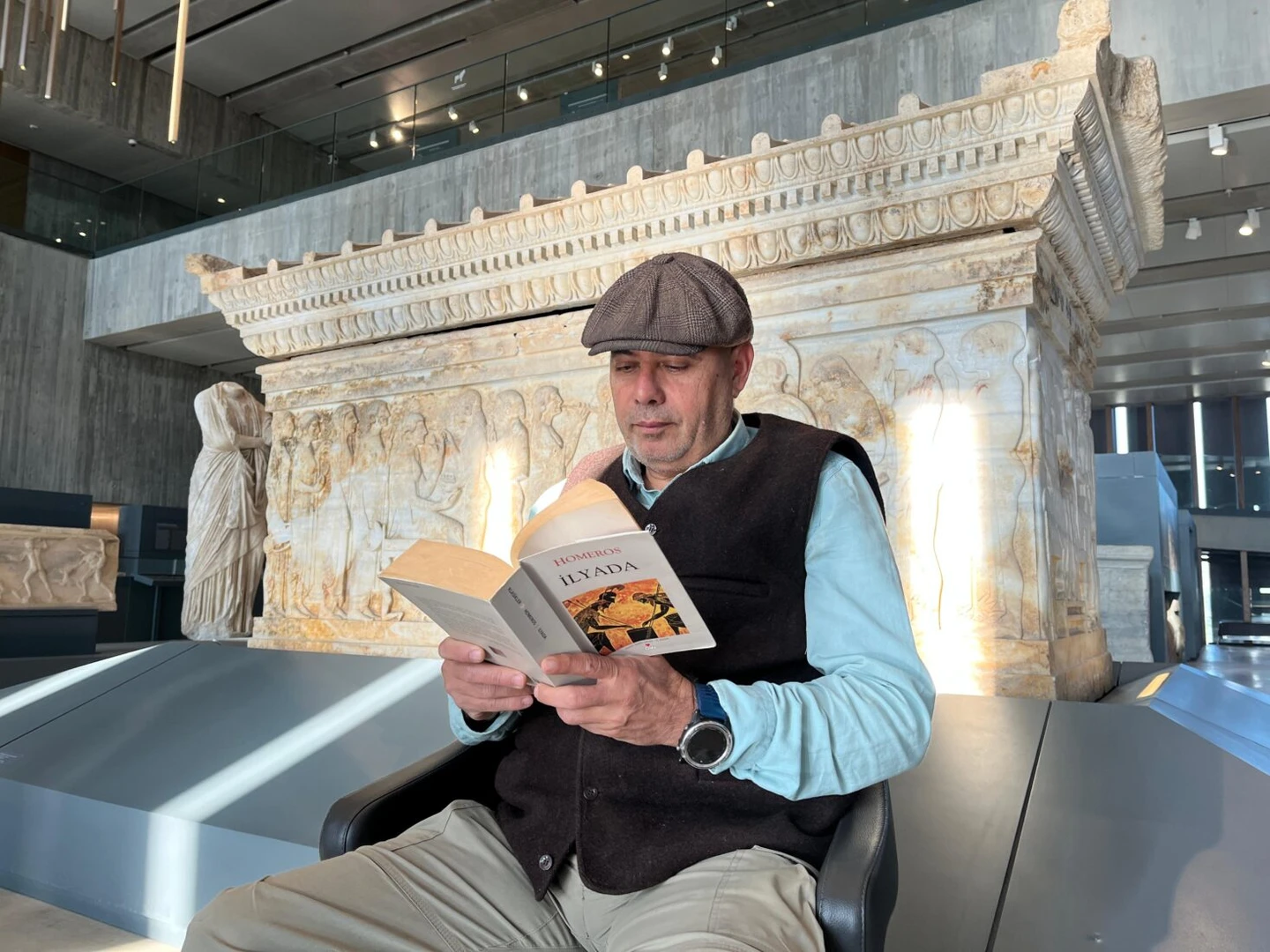 A participant reading Homer's Iliad in front of the Polyxena Sarcophagus.