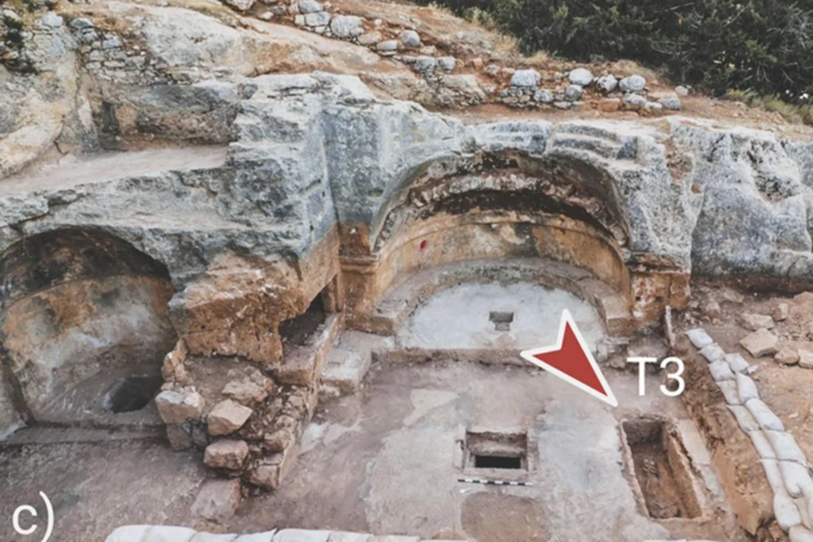 early christian - A wide-angle view of the ruins of El-Masani church in Israel, showing the excavated stone structure. An arrow points to the T3 tomb, where the remains of a female ascetic buried in chains were discovered.