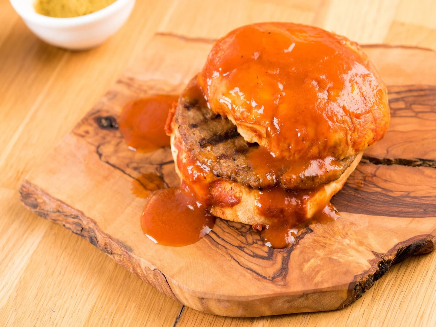 A Wet Burger served on a wooden platter. (Photo via Delivery Hero)