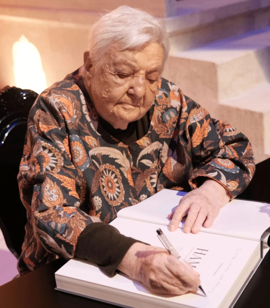 Professor Nurhan Atasoy signing a book for a reader. (Image credit: Türkiye Gazetesi)